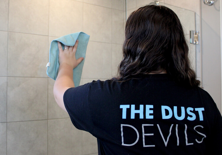 Cleaning Tech wiping shower glass